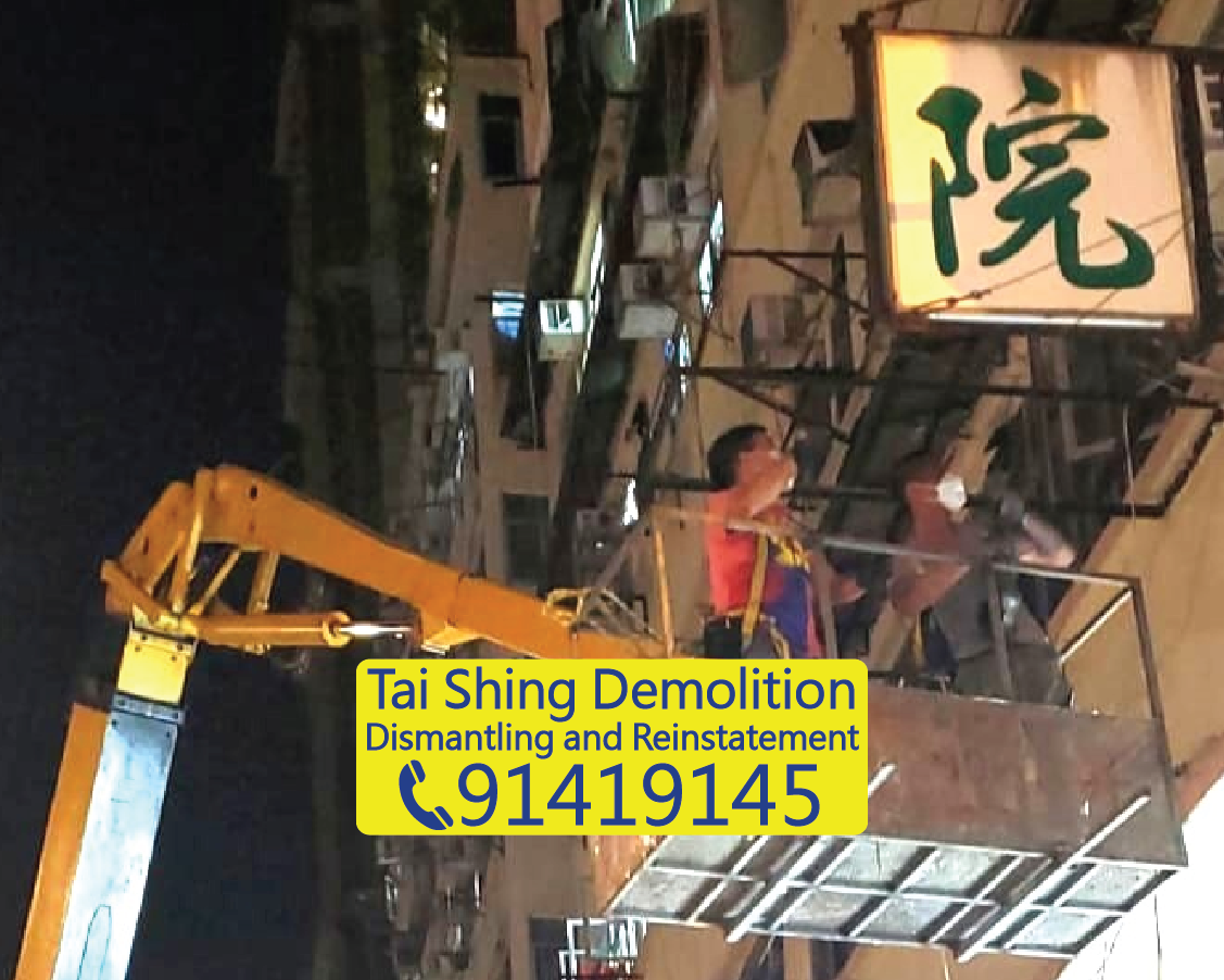 Nighttime high-level signboard removal in Hong Kong, workers using a boom lift to dismantle a suspended nursing home signboard from a building exterior, Tai Shing Demolition